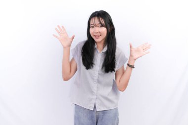 Beyaz çizgili gömlek giyen Endonezyalı kadın gülümsüyor ve iki elini de açıyor.