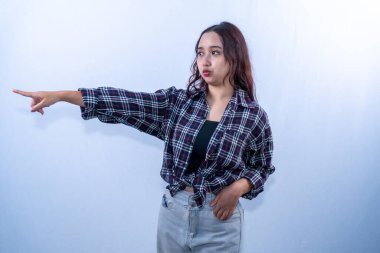 Siyah kareli gömlekli Endonezyalı kadın yan tarafı işaret ediyor.