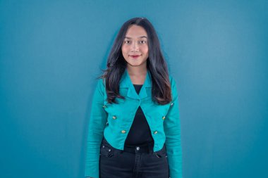 Endonezyalı Asyalı kadın donanma mavisi elbisesi giyiyor ve gülümsüyor.