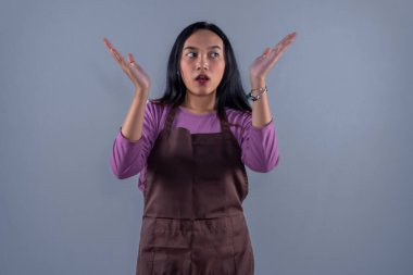 Mor giysili Endonezyalı kadın artı inançsız ifadeli kahverengi önlük.