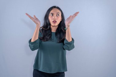 Asyalı Endonezyalı kadın yeşil kıyafetler giyiyor ve kafası karışık.