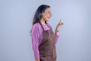 Mor giysili Endonezyalı kadın artı kenarı gösteren kahverengi önlük.