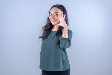 Endonezyalı mavi elbiseli kadın gülümsüyor ve söylemek istiyor.