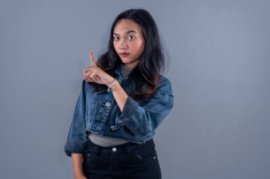 Kot pantolon giyen Endonezyalı bir kadın birine uyarı kodu veriyor.