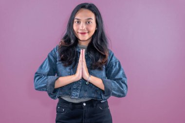 Endonezyalı kot ceket giyen Asyalı kadın tebrik ya da saygı göstergesi olarak