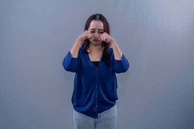 Mavi elbiseli Asyalı kadın üzgün ya da ağlıyor