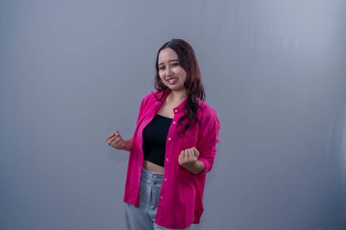 Asyalı Endonezyalı kadın kırmızı elbise giyiyor gülümseyerek başarıyı ifade ediyor