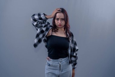 Siyah kareli gömlek giyen Asyalı kadın durumu kabul etmiyor.