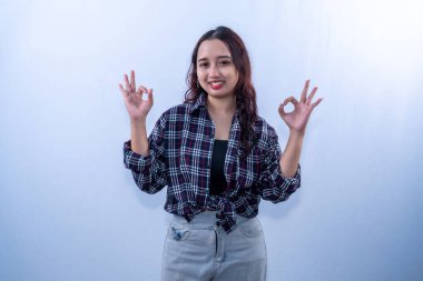 Kareli gömlek giyen Endonezyalı kadın gülümsüyor ve 