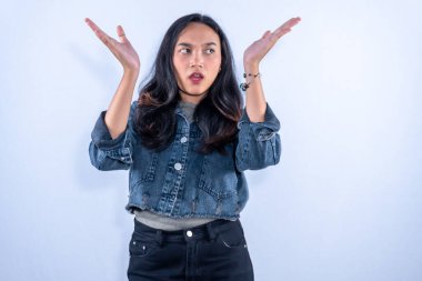 Elleri havada bir kadın, şaşkın bir ifade, ve ağzı açık, şaşkın görünüyor.