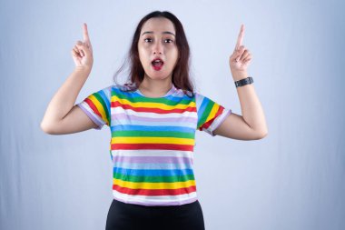 Şaşırmış genç bir kadın işaret parmaklarını yukarı kaldırarak ani bir fikir ya da farkındalık ifade ediyor..