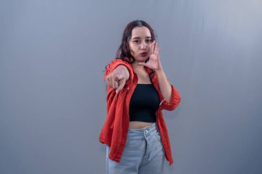 Turuncu elbiseli Endonezyalı bir kadın öne bakıyor ve bağırmak istiyor..