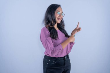 Asyalı Endonezyalı kadın mor gömlekli, gözlüklü, gülümseyen ve yüzünü gösteren.