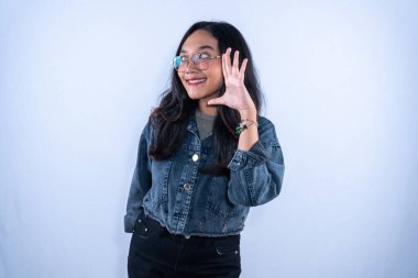 Endonezyalı, kot ceketli, gülümseyen ve sinyal veren Asyalı bir kadın.
