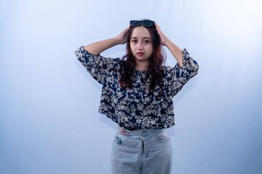 Endonezyalı, siyah çiçekli elbise giyen, başını güneş gözlüğü takan bir kadın.