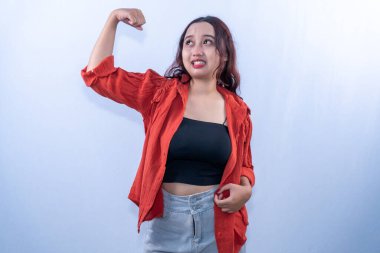 Turuncu elbiseli Endonezyalı kadın gülümsedi ve elini kaldırdı.