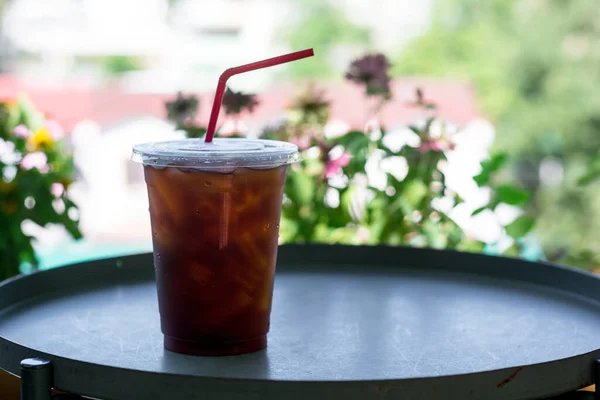 Ice black coffee or americano on dark table with green natural background. Energy drink in the morning concept.