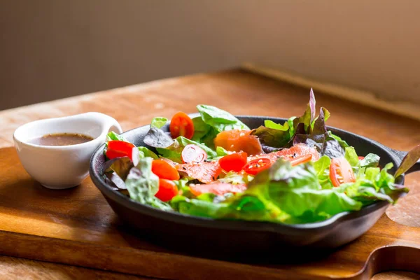 Smoke salmon Salad with green and red oak and cherry tomato served with sesame salad dressing. Homemade food. The concept for a tasty and healthy meal.