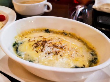 Restorandaki beyaz seramik kasede fırında ıspanak ve peynir.. 