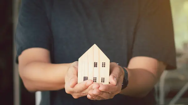 Konsep Investasi Real Estate Pengusaha Memegang Rumah Miniatur Kayu Tangan — Stok Foto