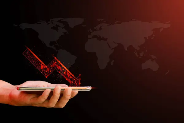 stock image Hand holding mobile or smartphone with red arrow graph drop arrow down with world map on red background. Money losing. Stock crisis and finance concept.