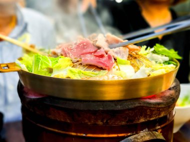 Tayland usulü barbekü. Sıcak tavada ızgara et ve domuz eti sebzeli ve fırında lezzetli bir çorba.