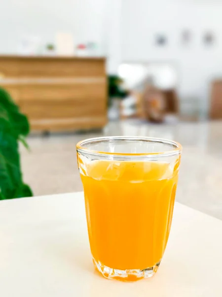 Food and beverage concept. A glass of orange juice on a white table in cafe.