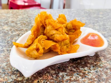 Ekşi soslu ve beyaz arka planda tatlı soslu, kıymalı kızarmış hamur tatlısı. Çıtır börek.. 