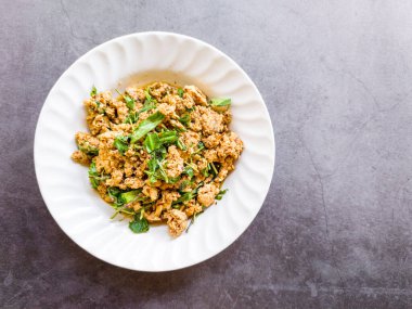 Kuzey Tayland usulü baharatlı domuz rostosu, Tayland bitkisiyle ya da Larb Moo, siyah tabakta. Üst görünüm.