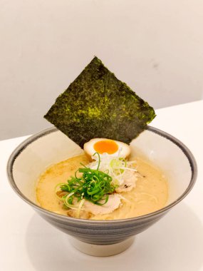 Japon yemeği konsepti. Tonkotsu Ramen, yosun, domuz eti, haşlanmış yumurta ve yeşil soğanlı.. 