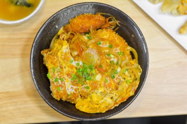 Japon yemeği konsepti. Tavuk ve yumurta kasesi mi yoksa yeşil soğanlı siyah bir kasede Oyakodon mu?. 