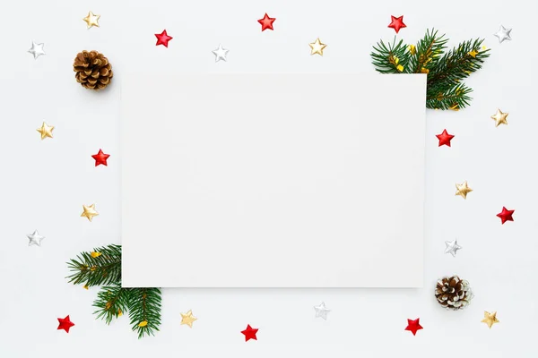 stock image Christmas, New Year holiday layout with copy space for text. Blank white paper in frame of natural fir tree branches, pinecones and decorations on white flat lay background