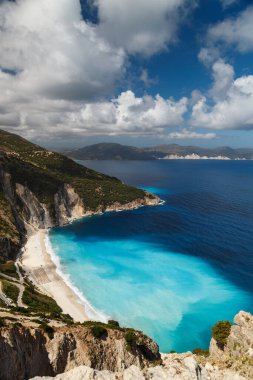 Myrtos Sahili 'nin üst manzarası ve muhteşem turkuaz ve mavi İyon Denizi suyu. Gökyüzü manzarası, ünlü ve son derece popüler Cephalonia, Yunanistan ve Avrupa 'daki yaz manzarası.