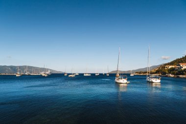 White yachts anchored in blue bay of Agia Efimia port, Cephalonia island, Greece