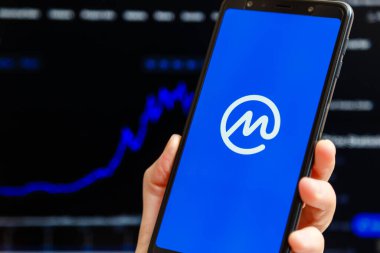 Ukrayna, Odessa - Ekim, 9, 2021: CoinMarketCap uygulaması akıllı telefon ekranında çalışan, arka planda şamdan şeması ticareti yapan cep telefonu. Dünyanın en güvenilir kripto para birimi veri yetkisi