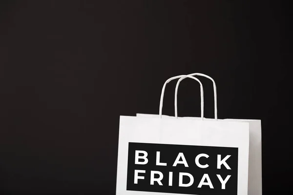 Black Friday white paper bag isolated on black background. Black friday, sale, discount, recycling, shopping and ecology concept