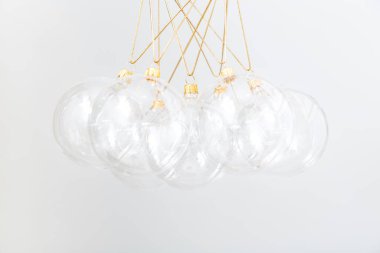 Beyaz arka planda şeffaf cam Noel topları. Moda Noel arka planı