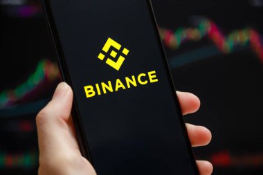 Ukraine, Odessa - June, 1 2021: Binance mobile app running at smartphone screen with a trading page at background. Binance one of the world's leading cryptocurrency exchange and trading platform.
