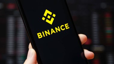 Ukraine, Odessa - June, 1 2021: Binance mobile app running at smartphone screen with a trading page at background. Binance one of the world's leading cryptocurrency exchange and trading platform.