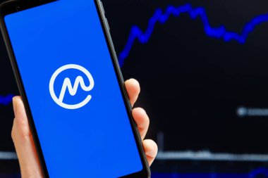Ukrayna, Odessa - Ekim, 9, 2021: CoinMarketCap uygulaması akıllı telefon ekranında çalışan, arka planda şamdan şeması ticareti yapan cep telefonu. En güvenilir kripto para birimi veri yetkisine sahip dünyalar