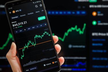 Ukrayna, Odessa - Ekim 9, 2021: CoinMarketCap mobil uygulamasında akıllı telefon ekranında çalışan ticari çift BTC USD, arka planda şamdan şeması ticareti. Güvenilir kripto para birimi veri yetkisi