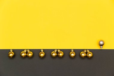 Noel, yeni yıl geometrik geçmişi. Tatil süslemeleri, parlak sarı ve gri zemin üzerinde altın ve gümüş toplar. Düz yat, boşluğu kopyala