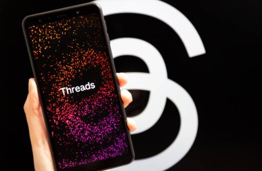 Ukrayna, Odesa - Temmuz 7 2023: Akıllı telefon ekranında çalışan Tehlike uygulaması ile el ele tutuşma cep telefonu. Tartışmalar, Meta Platformları 'nın sahibi olduğu çevrimiçi sosyal medya hizmeti. Twitter yarışmacısı.
