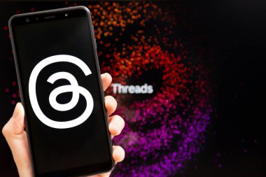 Ukrayna, Odesa - Temmuz 7 2023: Akıllı telefon ekranında çalışan Tehlike uygulaması ile el ele tutuşma cep telefonu. Tartışmalar, Meta Platformları 'nın sahibi olduğu çevrimiçi sosyal medya hizmeti. Twitter yarışmacısı.