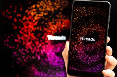 Ukrayna, Odesa - Temmuz 7 2023: Akıllı telefon ekranında çalışan Tehlike uygulaması ile el ele tutuşma cep telefonu. Tartışmalar, Meta Platformları 'nın sahibi olduğu çevrimiçi sosyal medya hizmeti. Twitter yarışmacısı.