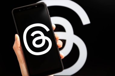 Ukrayna, Odesa - Temmuz 7 2023: Akıllı telefon ekranında çalışan Tehlike uygulaması ile el ele tutuşma cep telefonu. Tartışmalar, Meta Platformları 'nın sahibi olduğu çevrimiçi sosyal medya hizmeti. Twitter yarışmacısı.