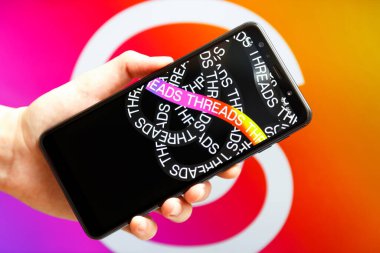 Ukrayna, Odesa - Temmuz 7 2023: Akıllı telefon ekranında çalışan Tehlike uygulaması ile el ele tutuşma cep telefonu. Tartışmalar, Meta Platformları 'nın sahibi olduğu çevrimiçi sosyal medya hizmeti. Twitter yarışmacısı.