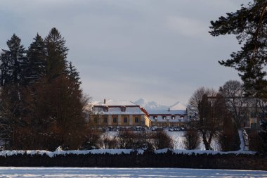 Avrig 'deki kar kaplı Brukenthal Sarayı ve Park' ın güzel kış fotoğrafı ve arka planda Karpat dağları, Romanya.