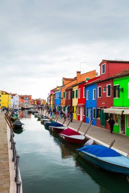 Burano, İtalya - 6 Ekim 2019: Burano Adası, Venedik, İtalya 'da kanalı, teknesi ve muhteşem renkli binaları olan resim gibi dar bir cadde. Parlak geleneksel renkli evler.