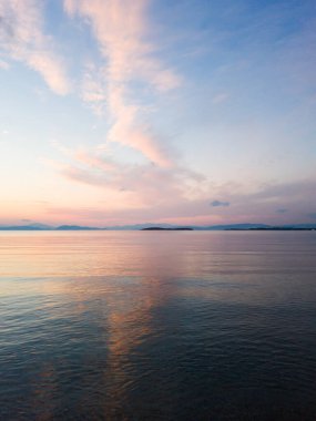 Yunanistan, Glyfada 'da akşam vakti deniz manzarası. Sakin denizdeki bulutların yansıması.